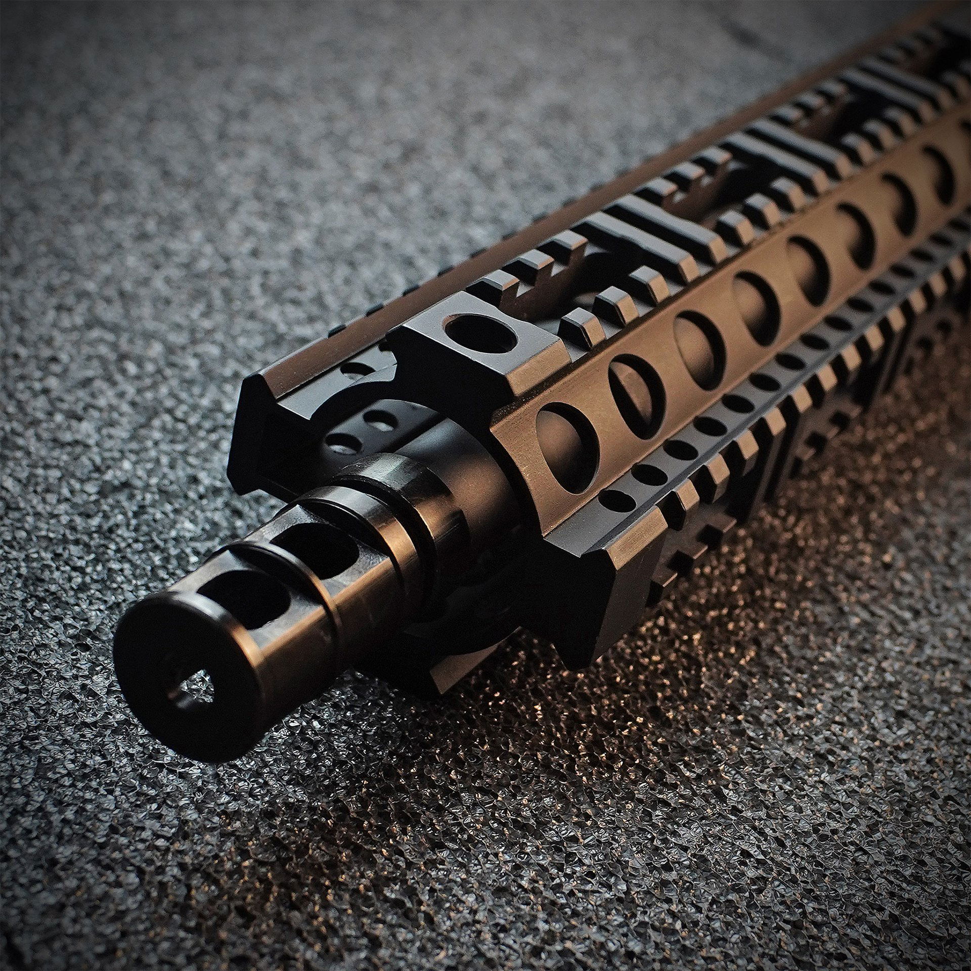 Wolverine Airsoft MTW Forged Series Gen 3 Semi-Only 10" - ab 18 Jahren Schwarzes Airsoftgewehr-Mündungsstück mit taktischer Schiene auf strukturiertem Untergrund.
