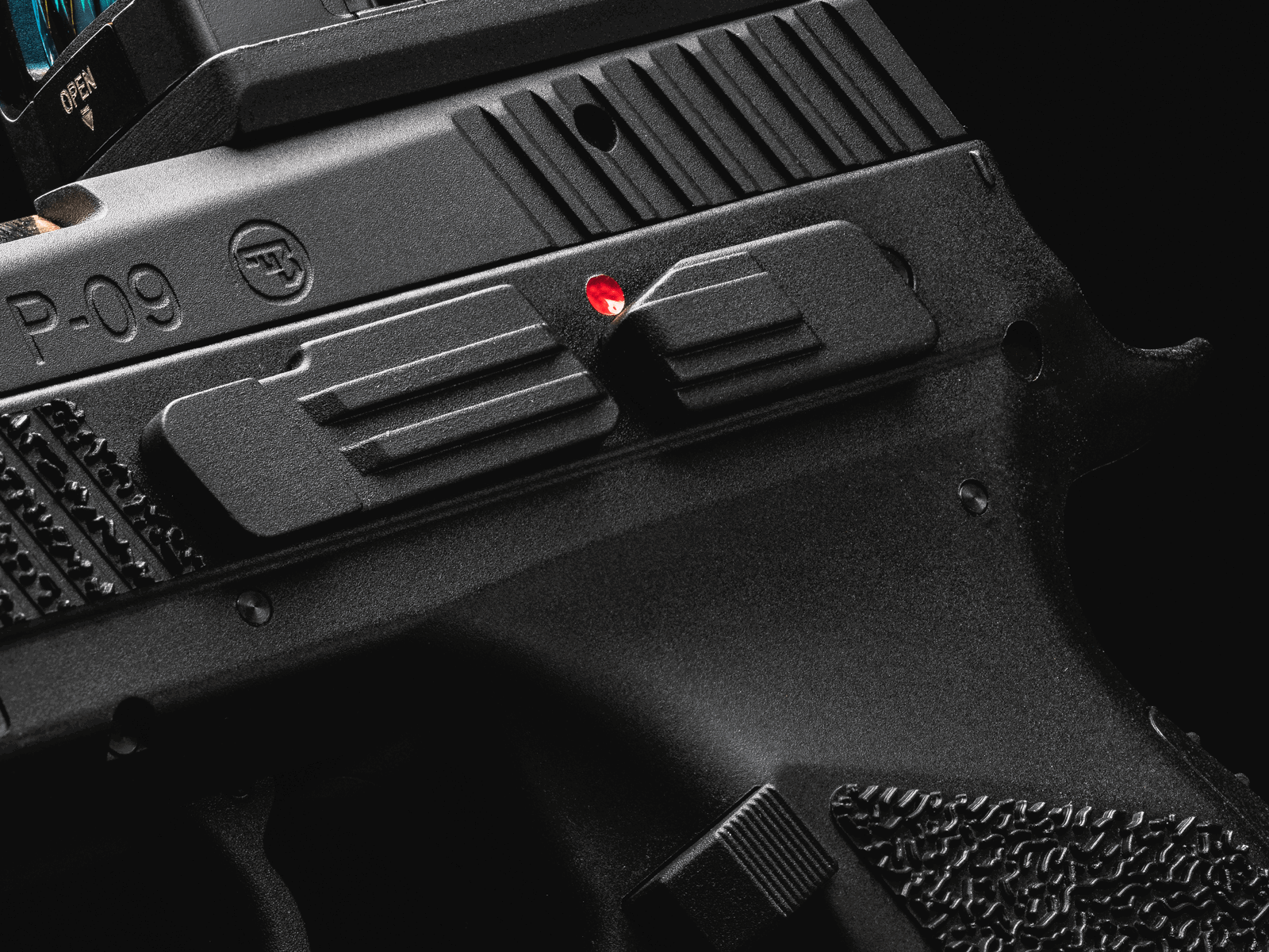 Nahaufnahme eines schwarzen Airsoft-Pistolen-Schlittens mit Textur und roter Markierung.
