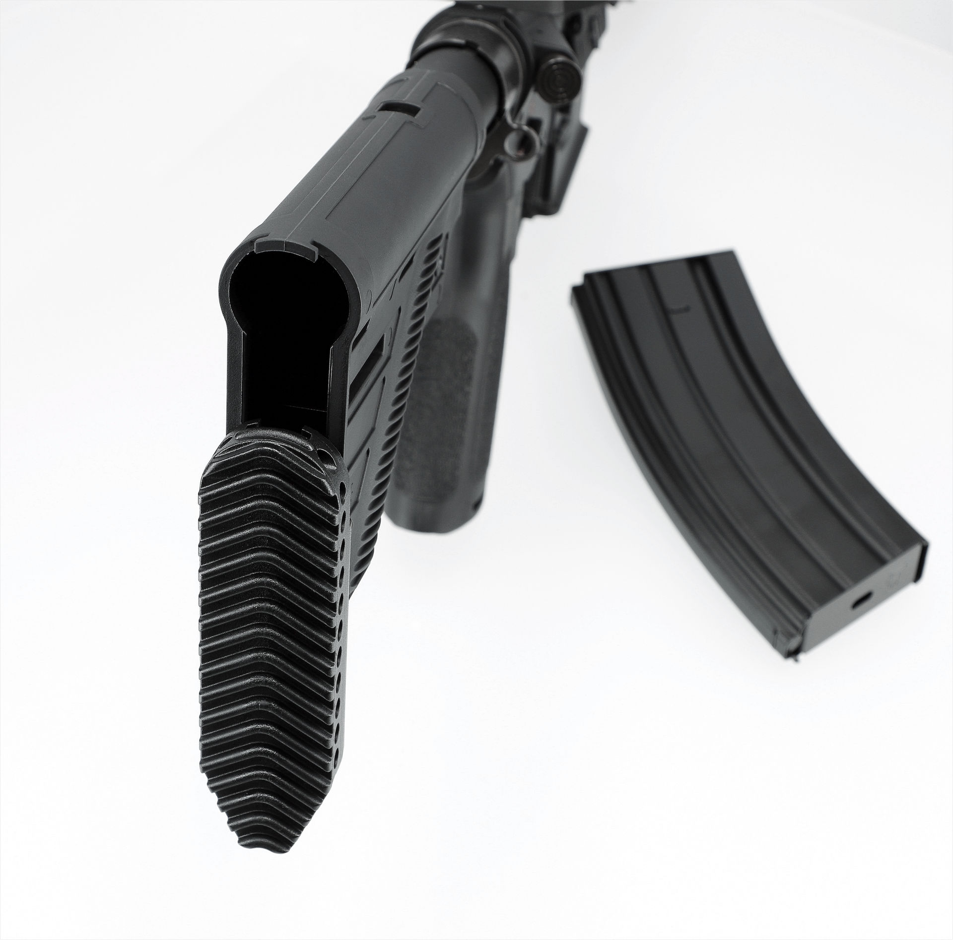 Airsoft-Gewehrlauf und herausgenommenes Magazin, Nahaufnahme in schwarz.