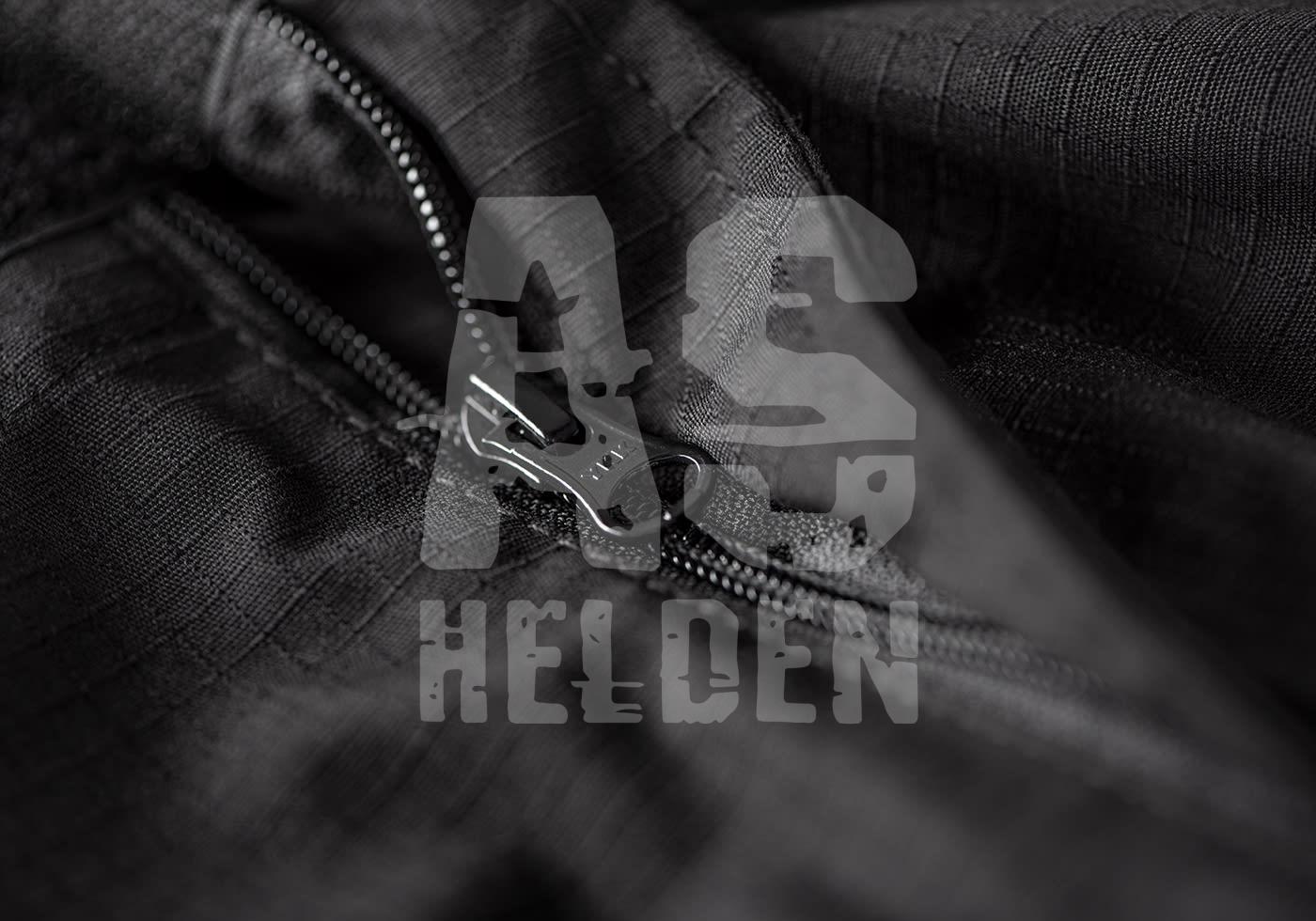 Nahaufnahme eines schwarzen Reißverschlusses auf taktischem Stoff, mit Airsoft Helden Logo im Hintergrund.