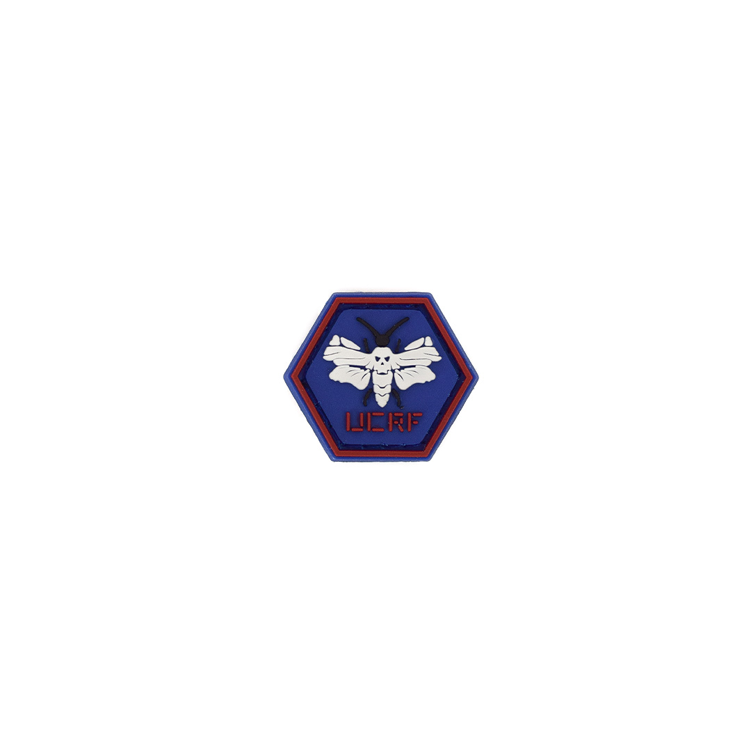 Sechseckiger Patch mit weißer Motte und rotem "UCRF"-Text auf blauem Hintergrund.