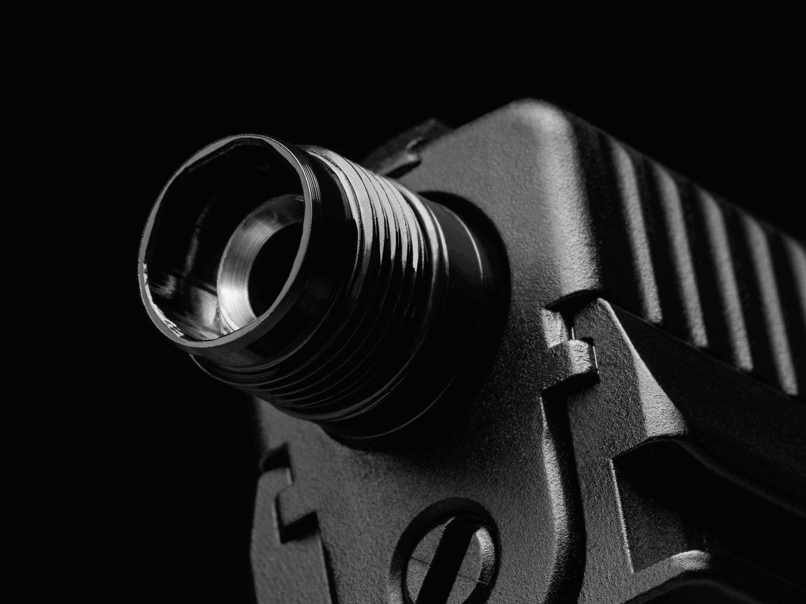 Nahaufnahme einer Metall-Mündung eines Airsoft-Pistolenlaufs mit Gewinde, schwarzer Hintergrund.