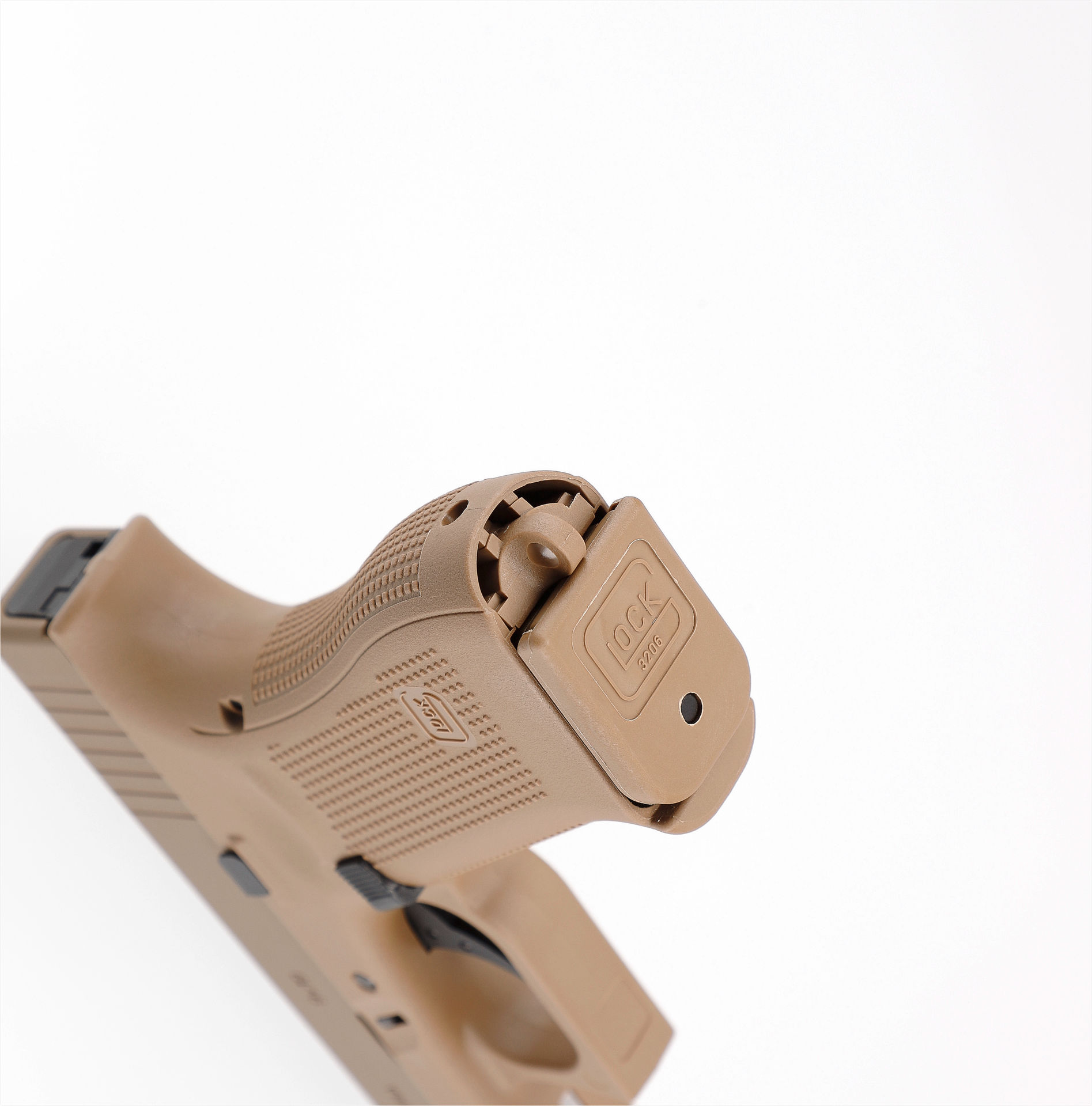 Detail einer tanfarbenen Airsoft-Pistole mit sichtbarer Unterseite des Magazins.