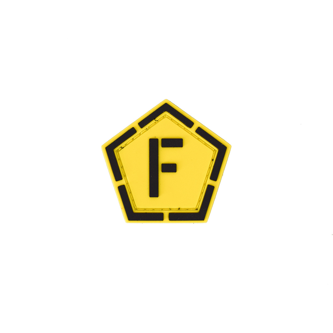 Gelbes, fünfeckiges Airsoft-Patch mit schwarzem "F" in der Mitte.