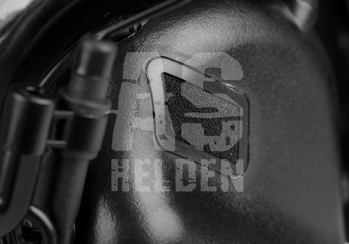 Nahaufnahme eines schwarzen Airsoft-Helmteils mit "Helden" Logo darauf.