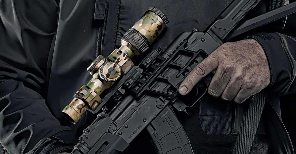 Person mit Gewehr in Tarnoptik und Zielfernrohr hält den Abzug fest.
