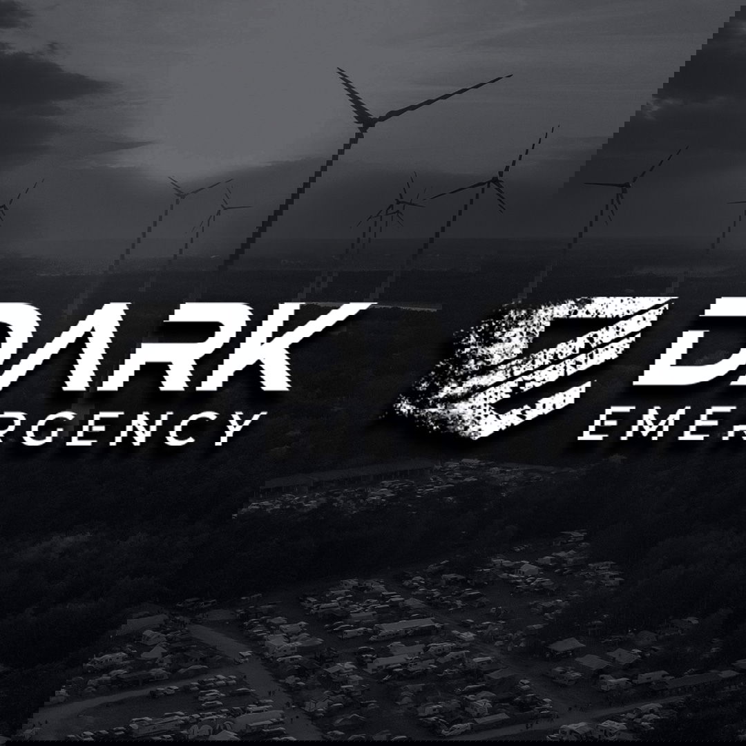 Logo "Dark Emergency" vor Windrädern und Campingplatz.