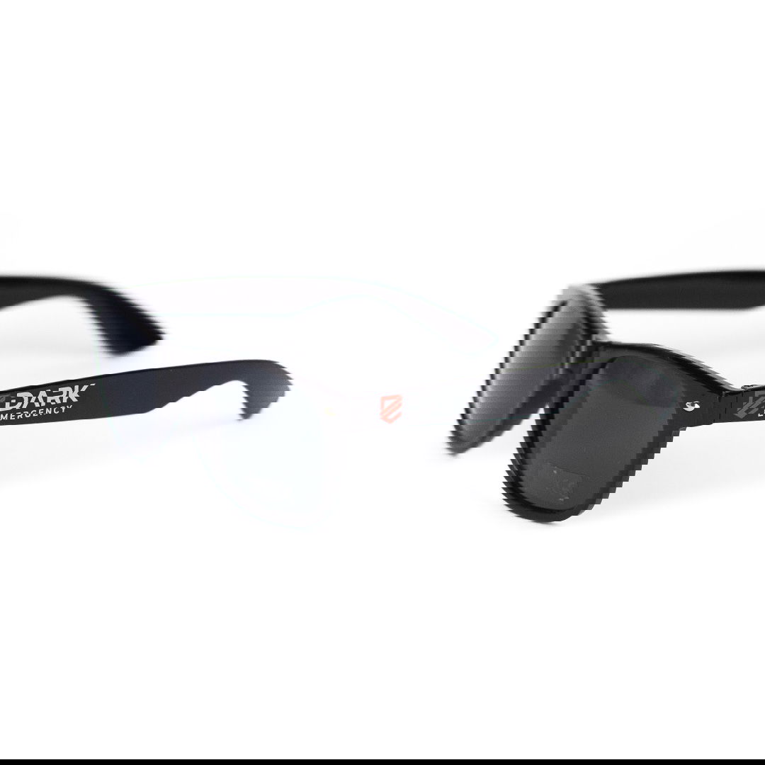 Dark Emergency Sonnenbrille  Schwarze Sonnenbrille mit "Dark Emergency" Logo auf den Bügeln, schwarzer Rahmen, dunkle Gläser.