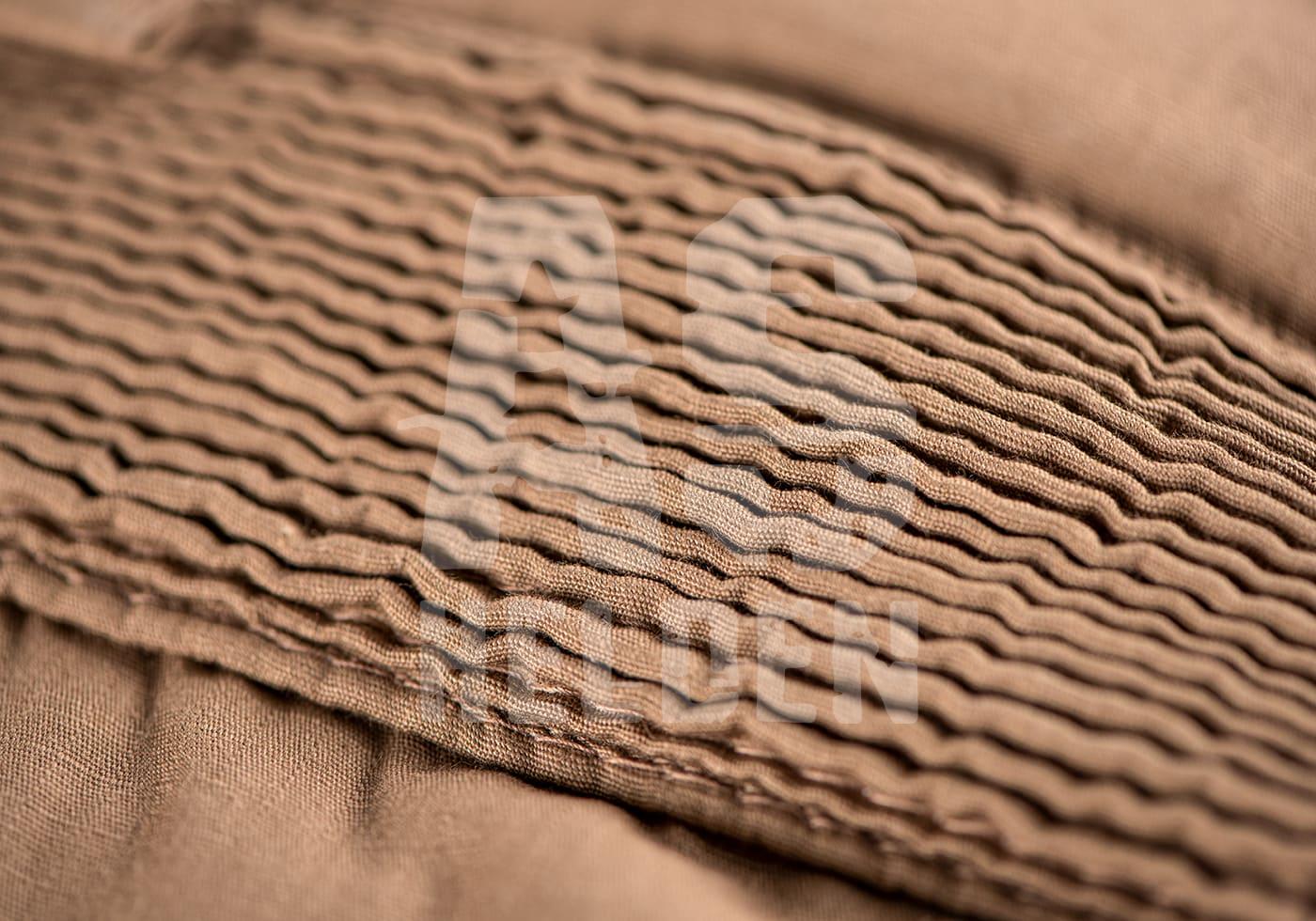 Nahaufnahme von wellenförmigem, braunem Stoff, Detailaufnahme.