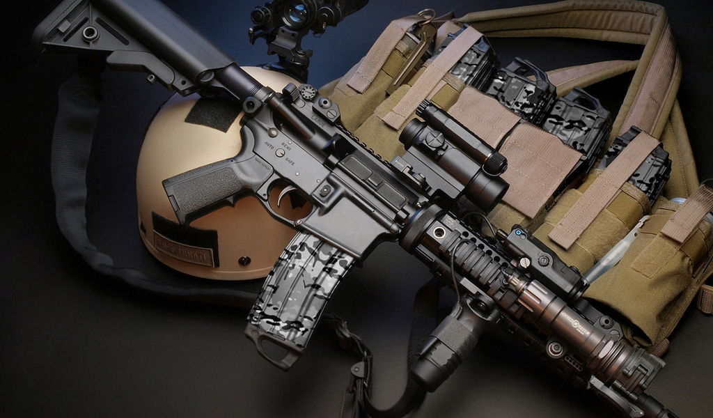 Airsoft-Ausrüstung mit Gewehr, Helm und taktischer Weste mit Magazintaschen, auf dunklem Hintergrund.