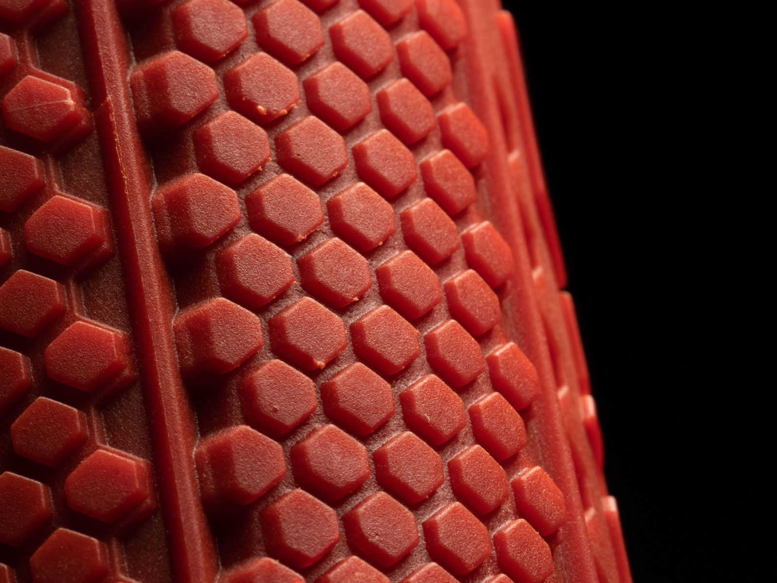 Roter, hexagonaler Gummigriff mit strukturierter Oberfläche für besseren Halt.
