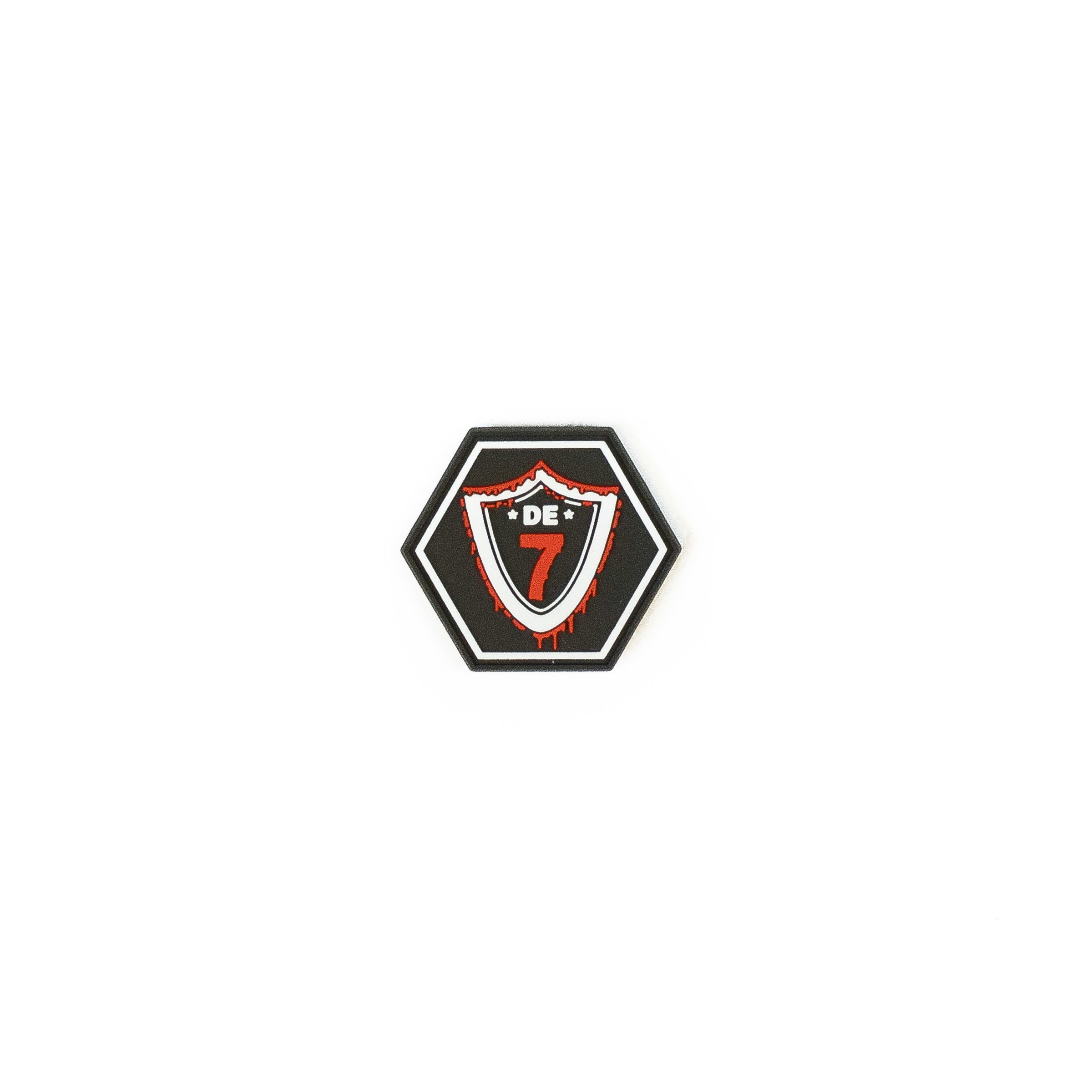 Hexagonales Abzeichen mit "DE 7", rotem Schild auf schwarzem Hintergrund. Optimal für Airsoft-Teams.