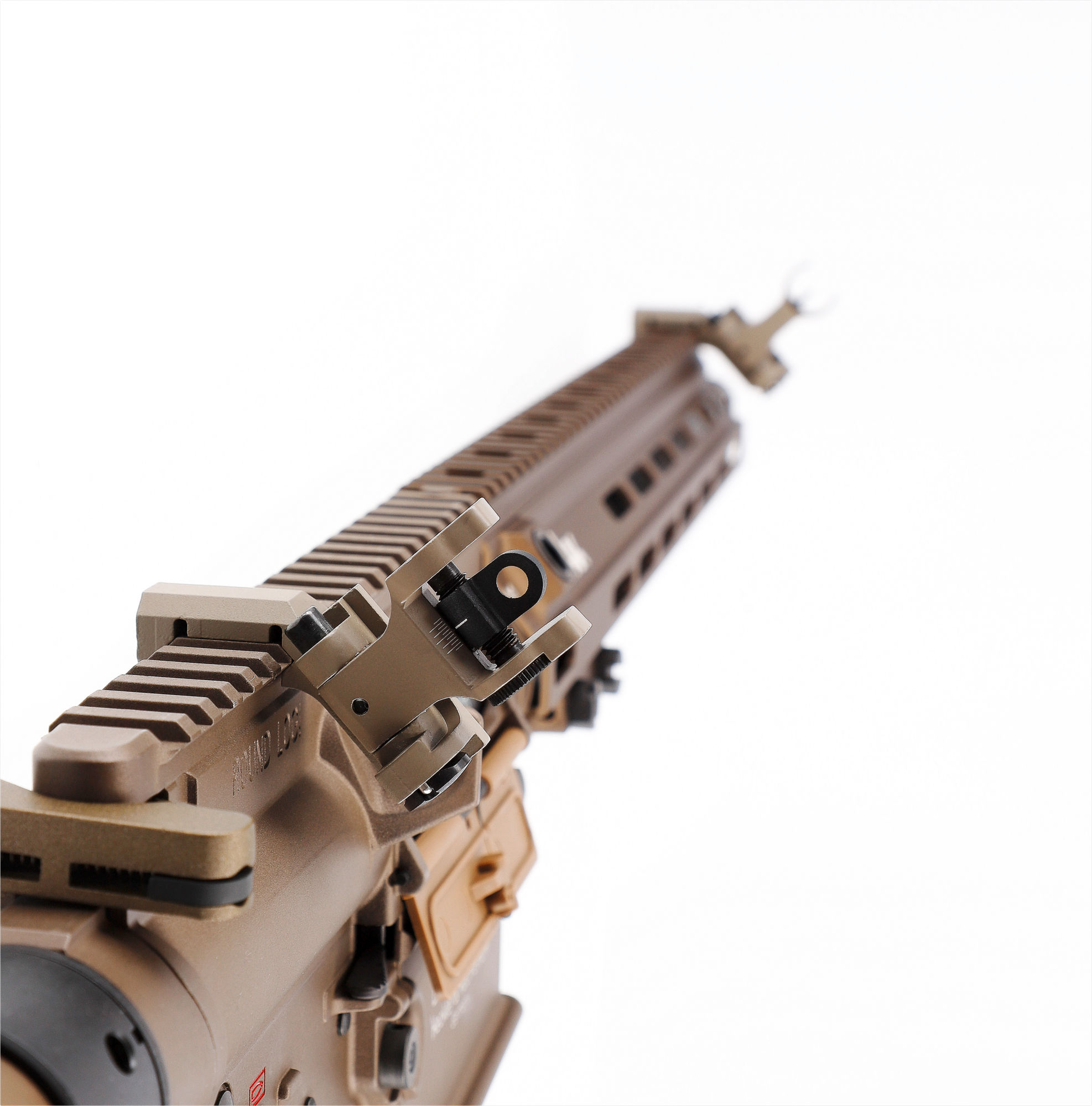 Nahaufnahme einer Airsoft-Waffe in Tan-Farbe mit Klappvisier, Fokus auf die Oberseite.