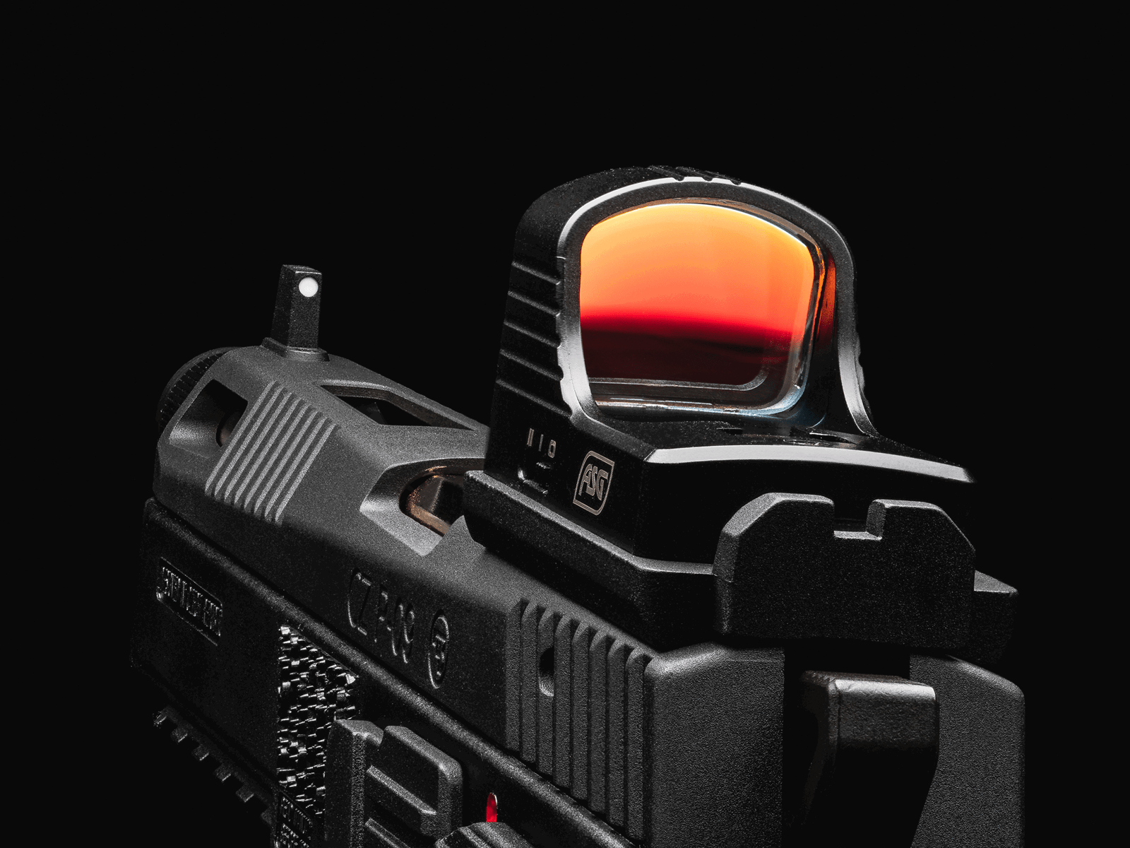 Airsoft-Pistole mit montiertem Rotpunktvisier vor schwarzem Hintergrund.