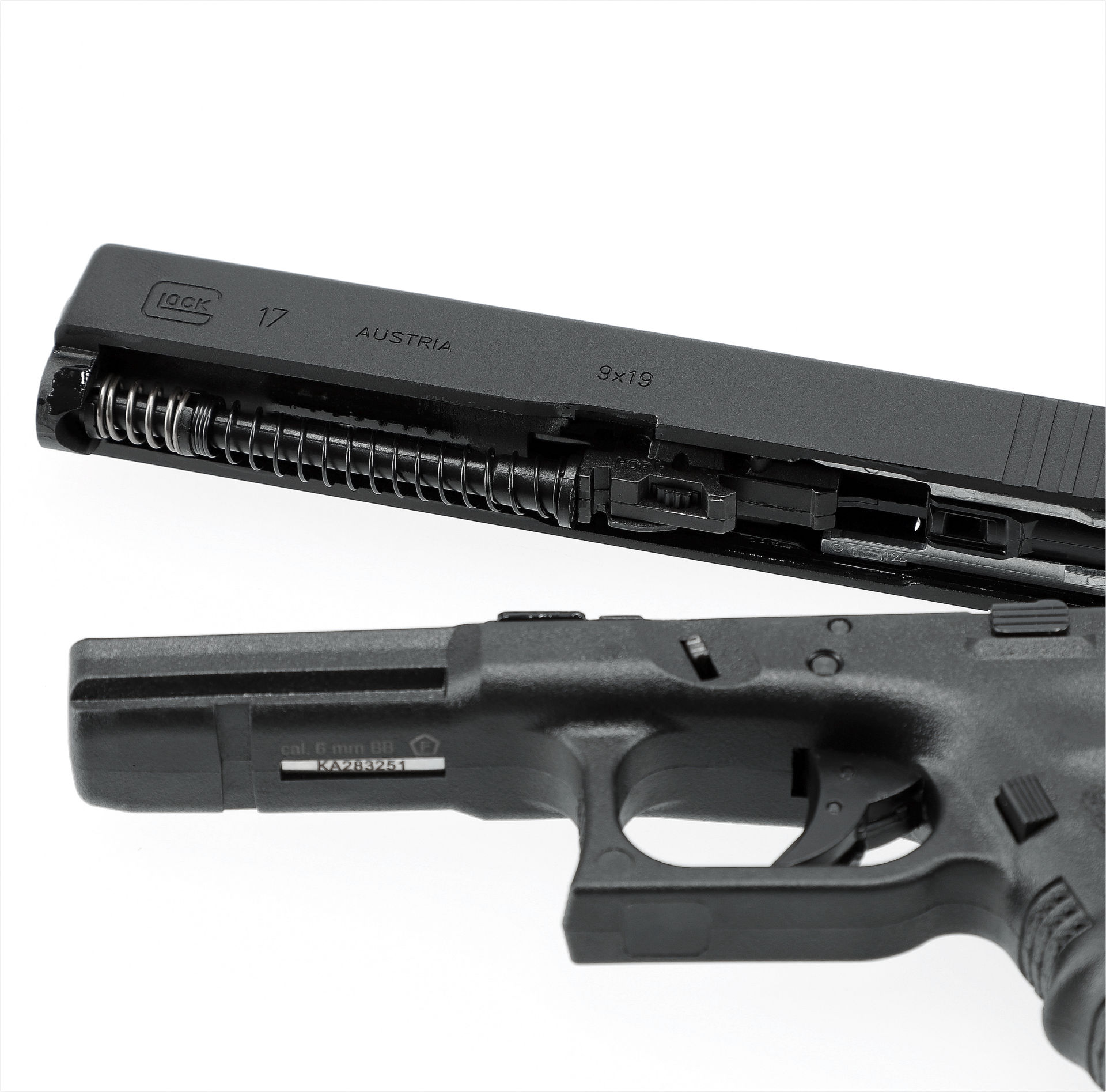 Zerlegte Airsoft-Pistole Glock 17 mit geöffnetem Schlitten und freiliegender Federmechanik.