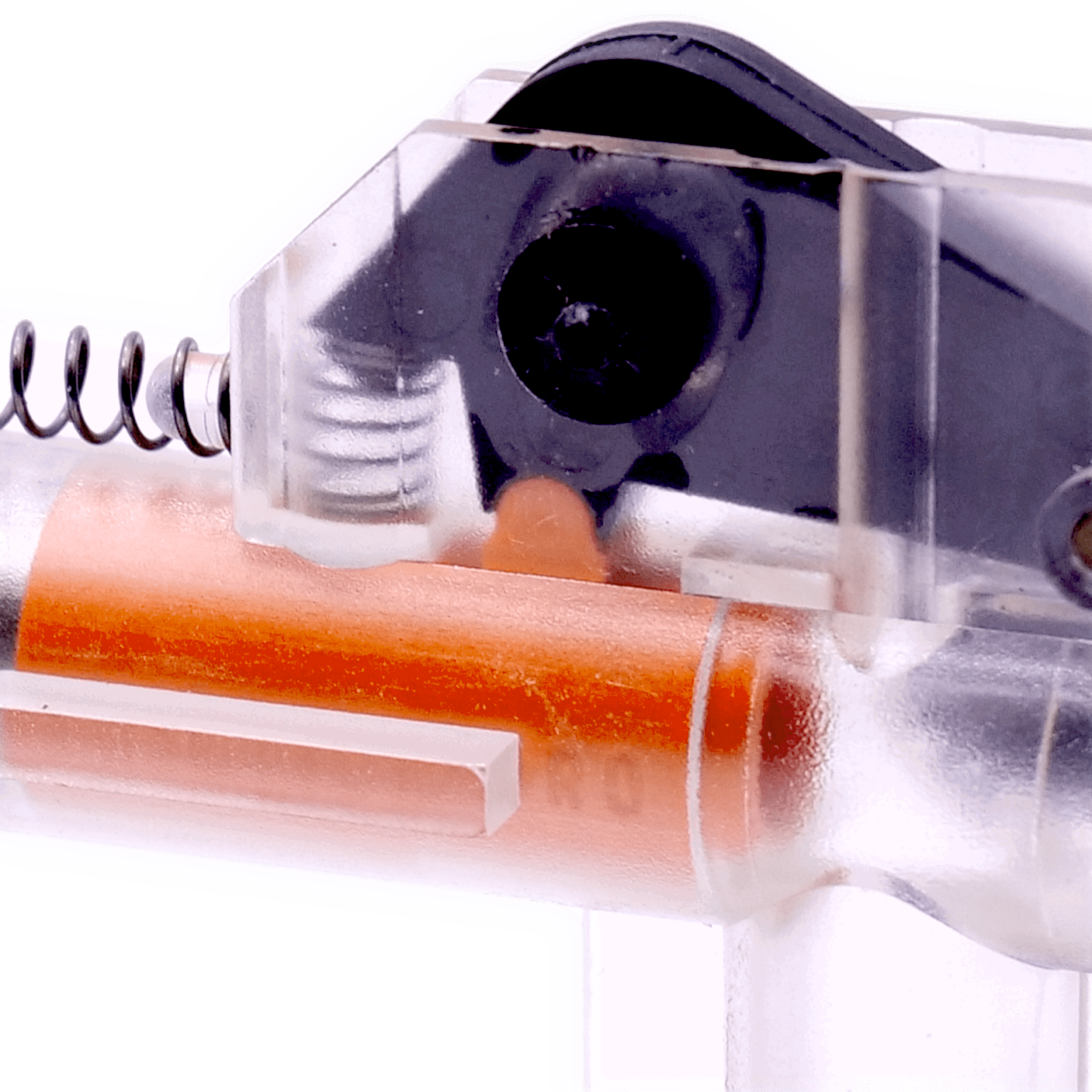Nahaufnahme eines transparenten Mechanismus mit Spiralfeder und orangem Element.