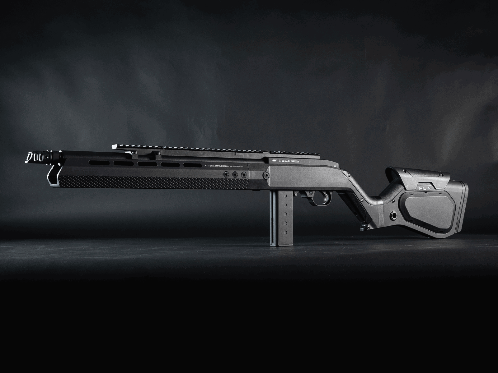 Airsoft-Gewehr in seitlicher Ansicht, modernes Design, schwarzes Finish, auf dunklem Hintergrund.