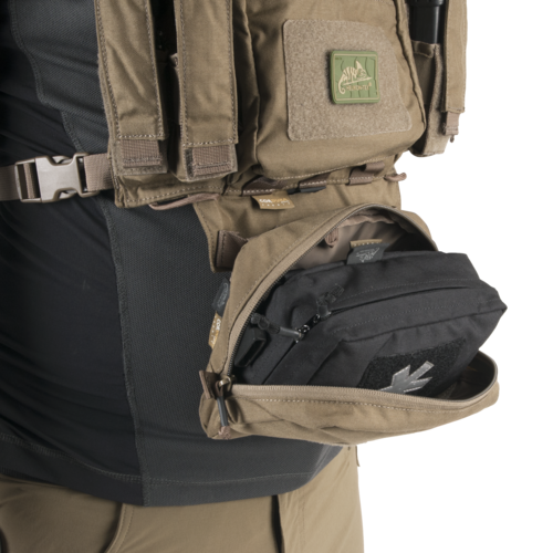 Airsoft-Tasche an Weste mit Reißverschluss geöffnet, zeigt inneren Stauraum und taktische Ausrüstung.