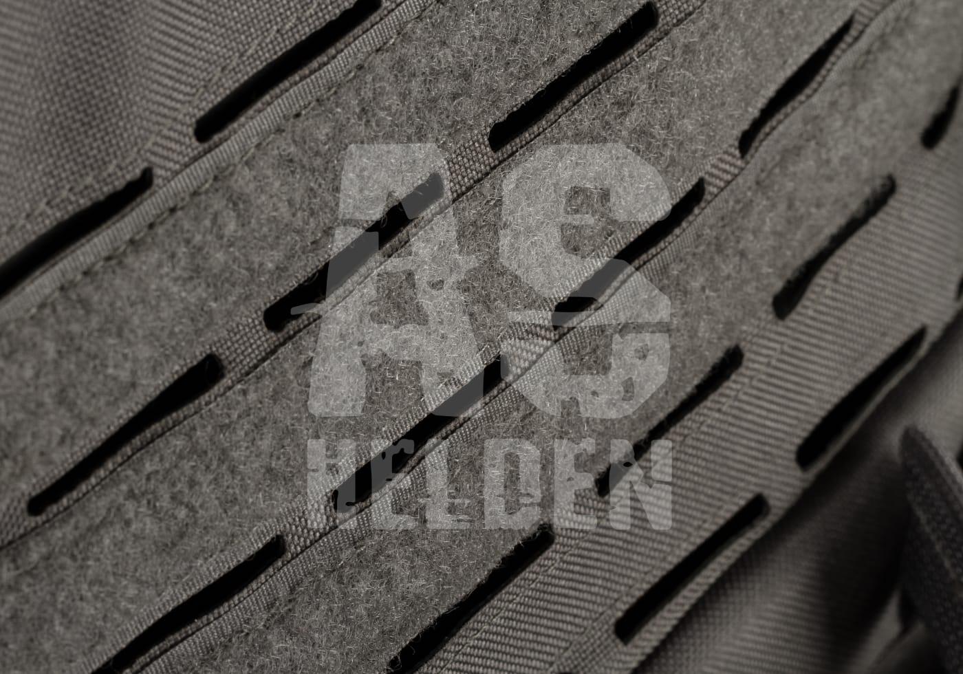 Nahaufnahme eines taktischen Airsoft-Westenmaterials mit Lasercut-Molle-Schlitzen in Grau.