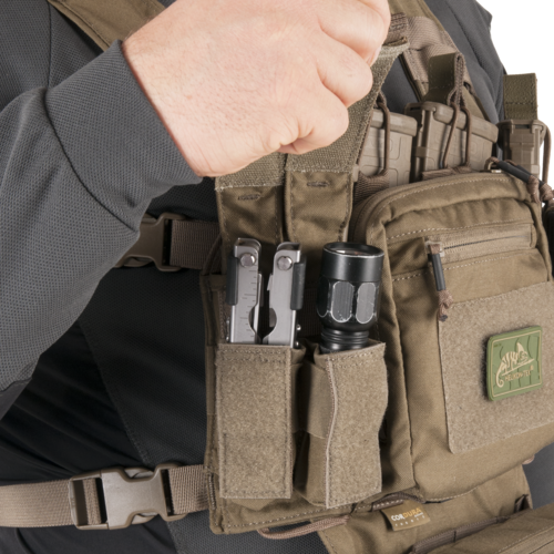 Taktische Weste mit Taschenlampe und Multitool in speziellen Fächern.