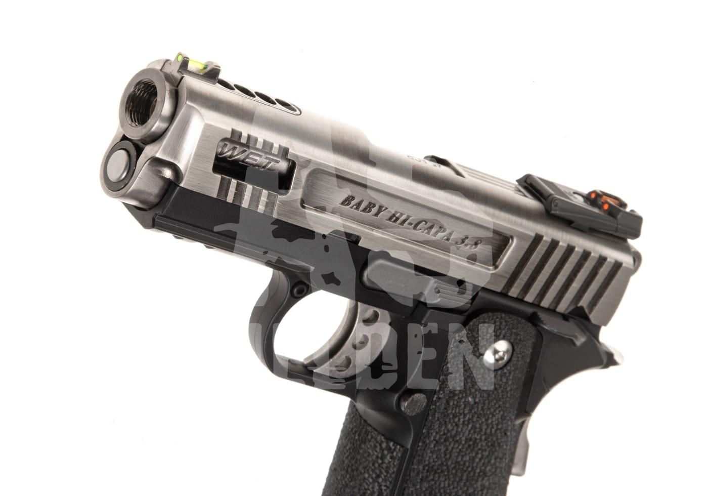 Silberne Airsoft-Pistole, Modell "Baby Hi-Capa 3.8", mit strukturiertem Griff und Sichtfenster am Verschluss.