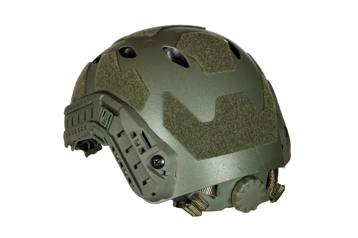 Taktischer grüner Airsoft-Helm mit Klettflächen, seitlichen Schienen und Belüftungsöffnungen.