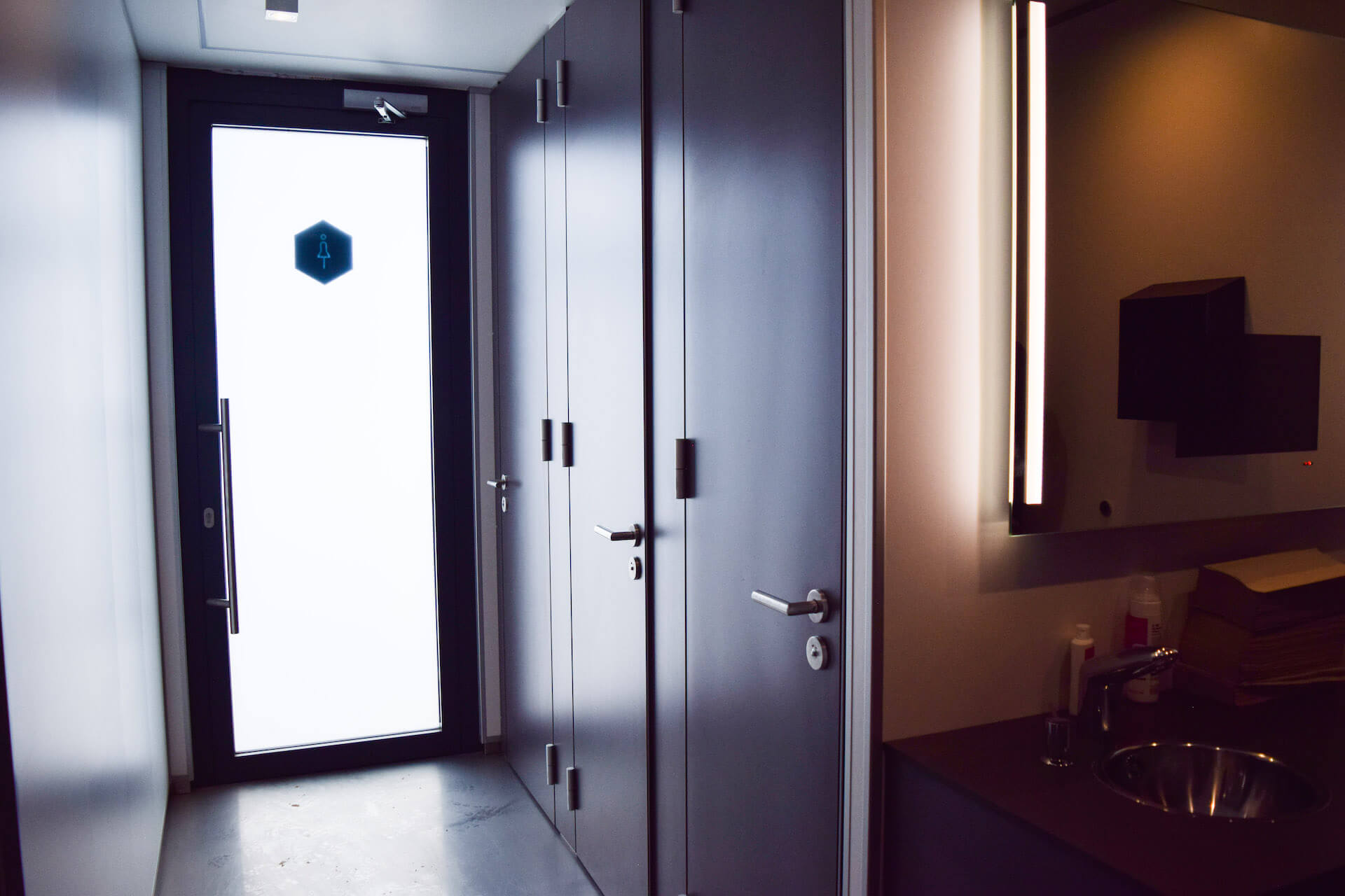 Moderne Toilettentür mit Waschtisch und Spiegel.