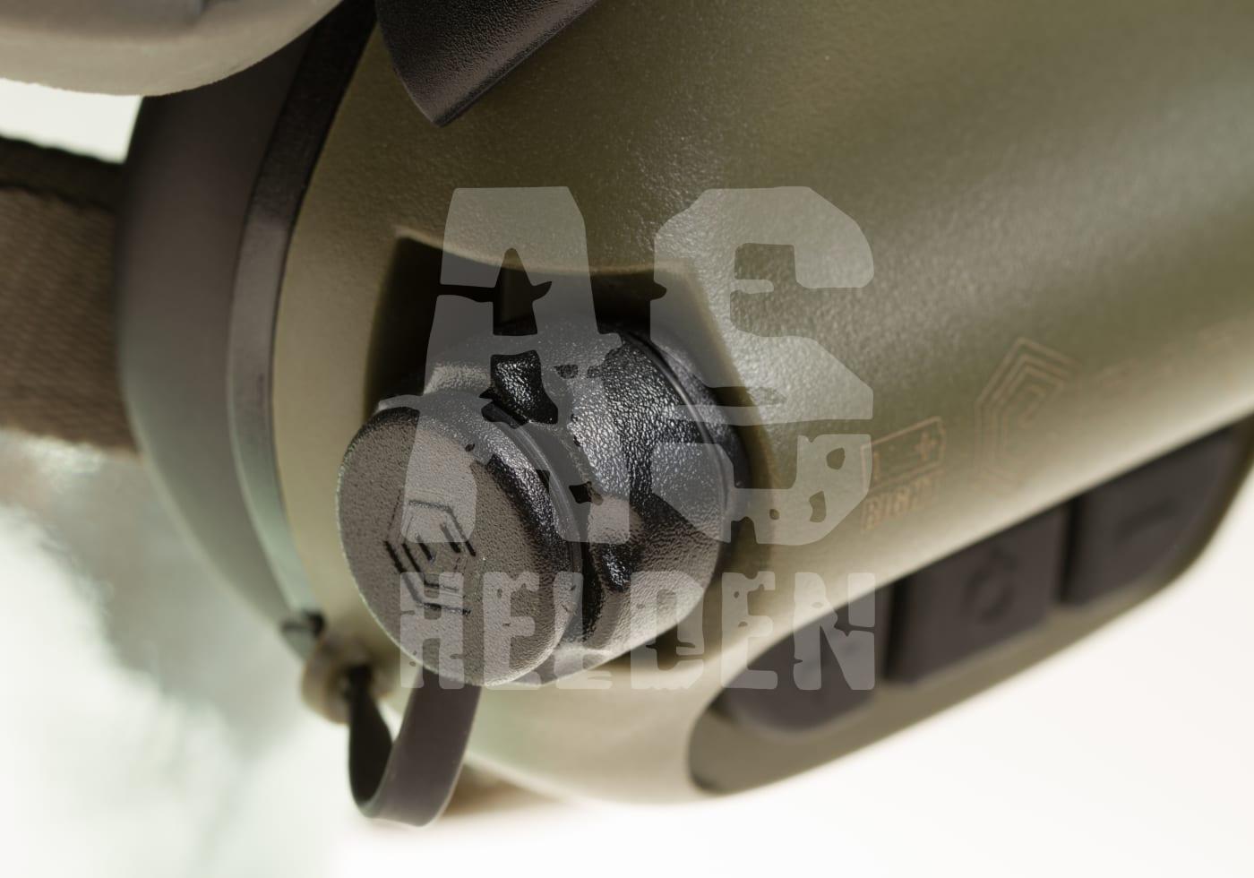 Nahaufnahme eines grünen Kopfhörers mit Lautstärkeregler, Airsoft Helden-Logo im Vordergrund.