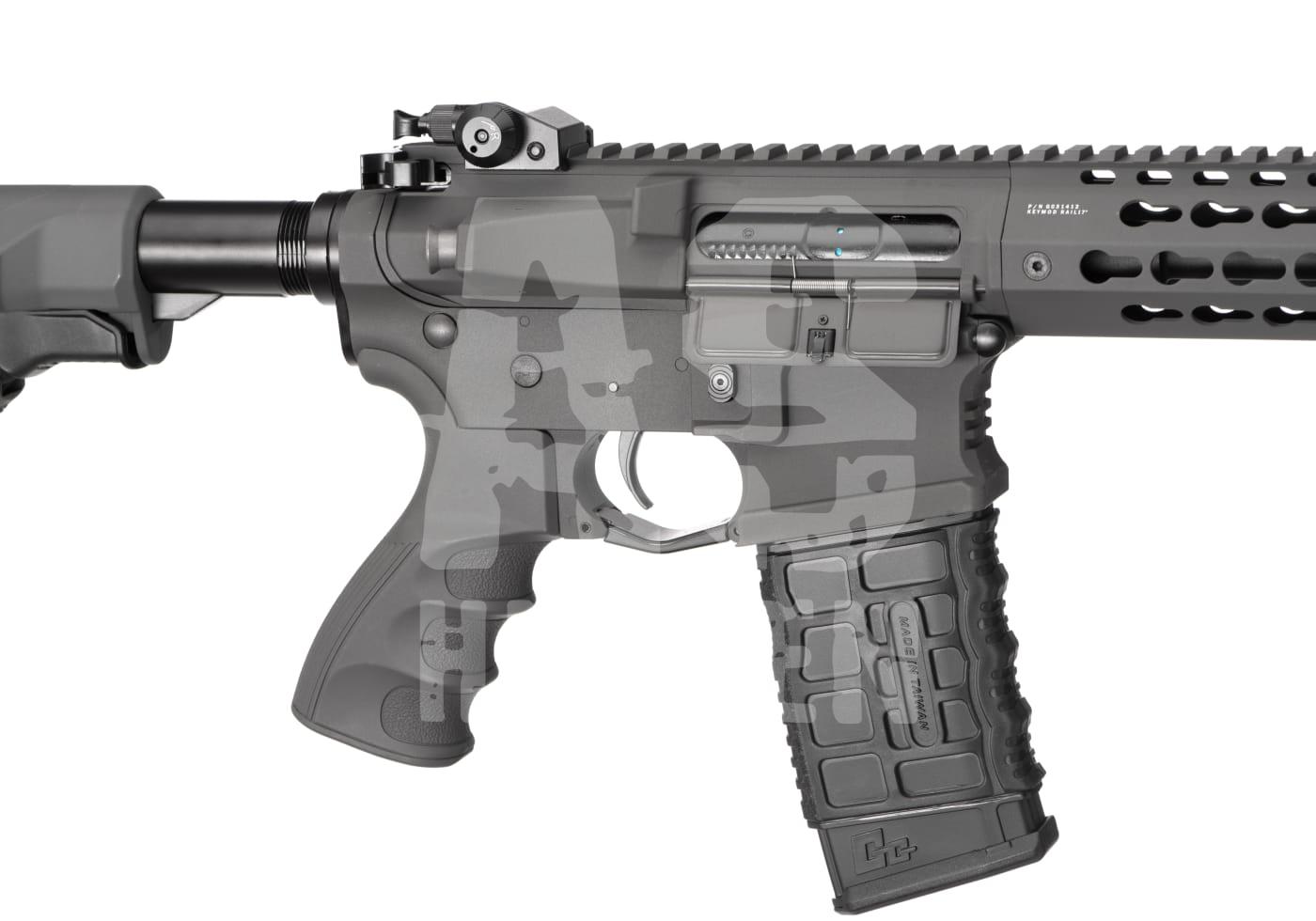 Detailaufnahme eines Airsoft-Gewehrs mit taktischem Griff und Magazin, graue Tarnung.