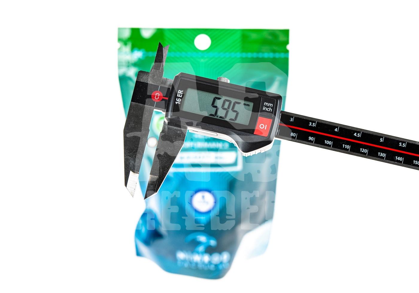 Digitaler Messschieber misst Softair-Kugel, Display zeigt 5,95 mm, vor grün-blauer Verpackung.