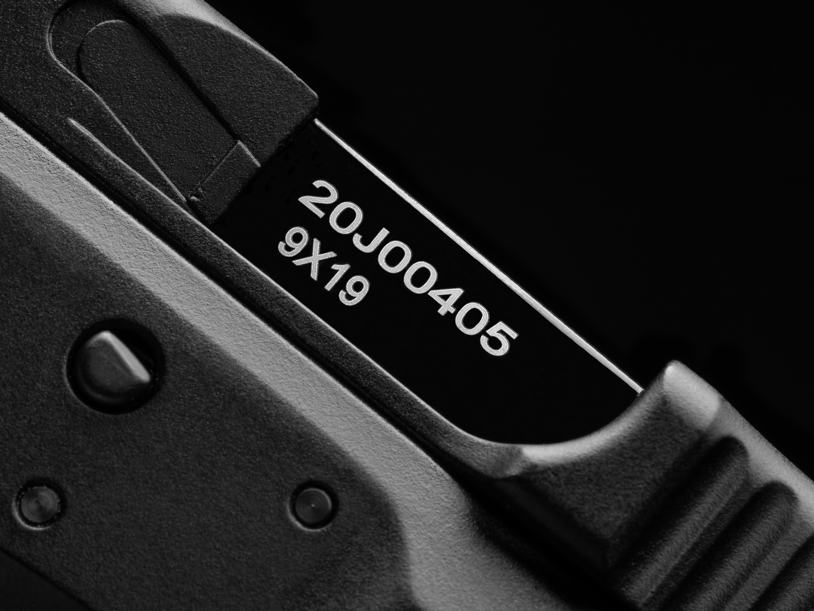 Nahaufnahme einer schwarzen Airsoft-Pistole mit Gravur "20J00405" und "9X19".