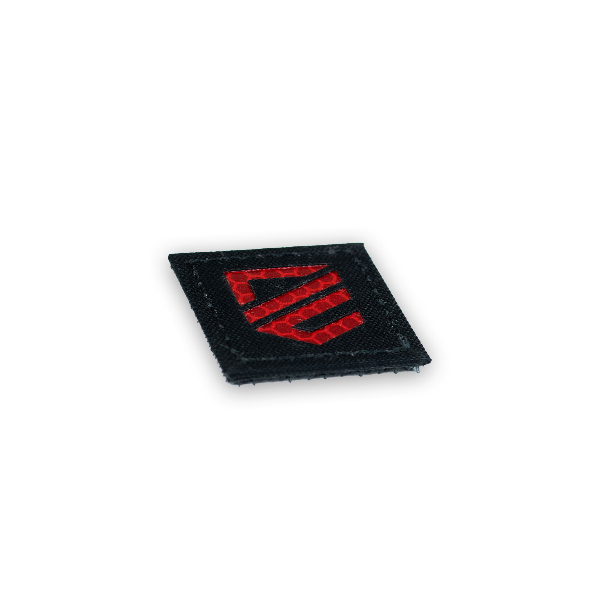 Schwarzer Airsoft-Patch mit reflektierendem roten Wappen.