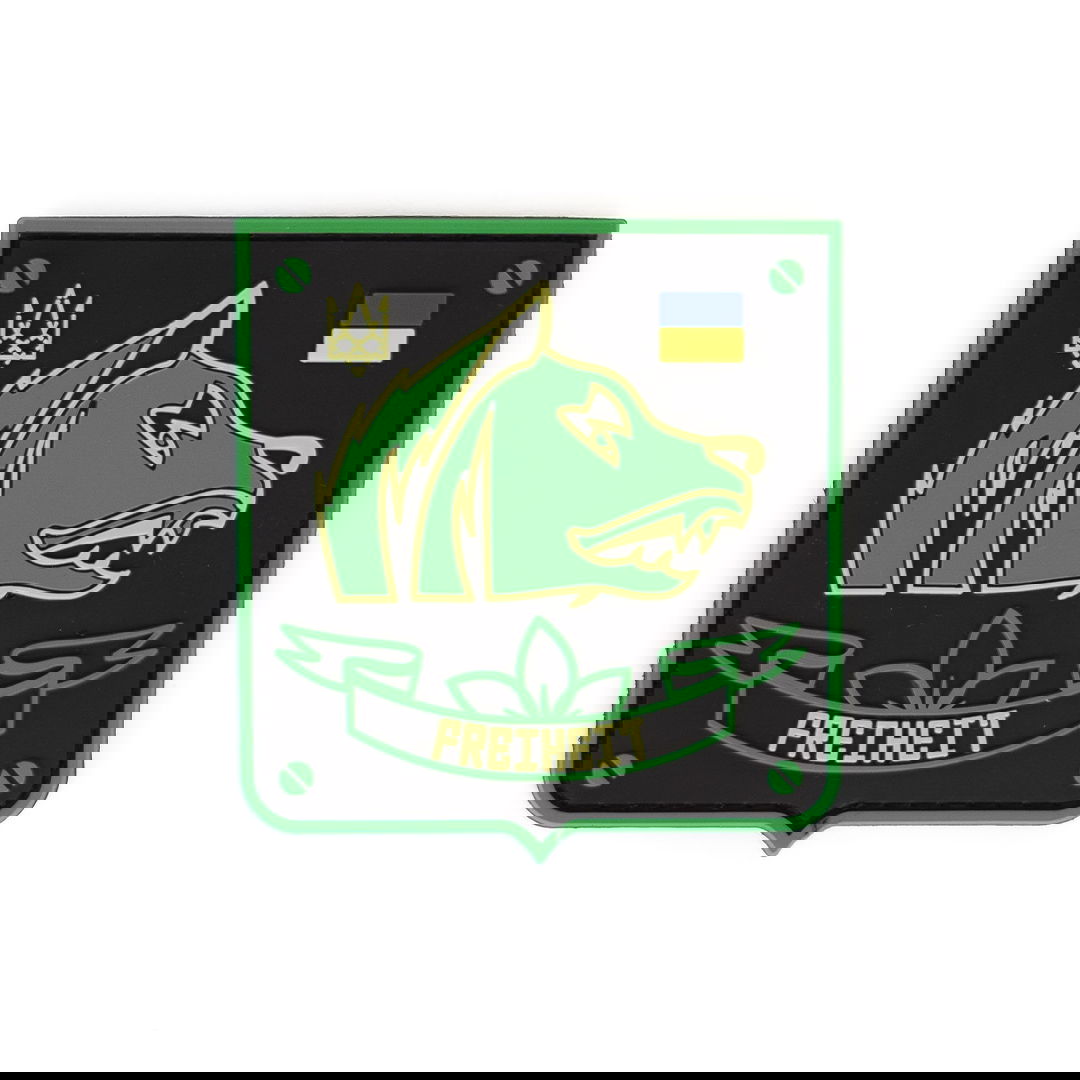 Abzeichen mit grünem Wolfskopf, Schriftzug "FREIHEIT", ukrainischer Flagge und Dreizack auf schwarzem Hintergrund.