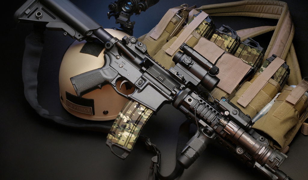 Airsoftgewehr mit Zubehör, Helm und taktischer Weste auf schwarzem Hintergrund.