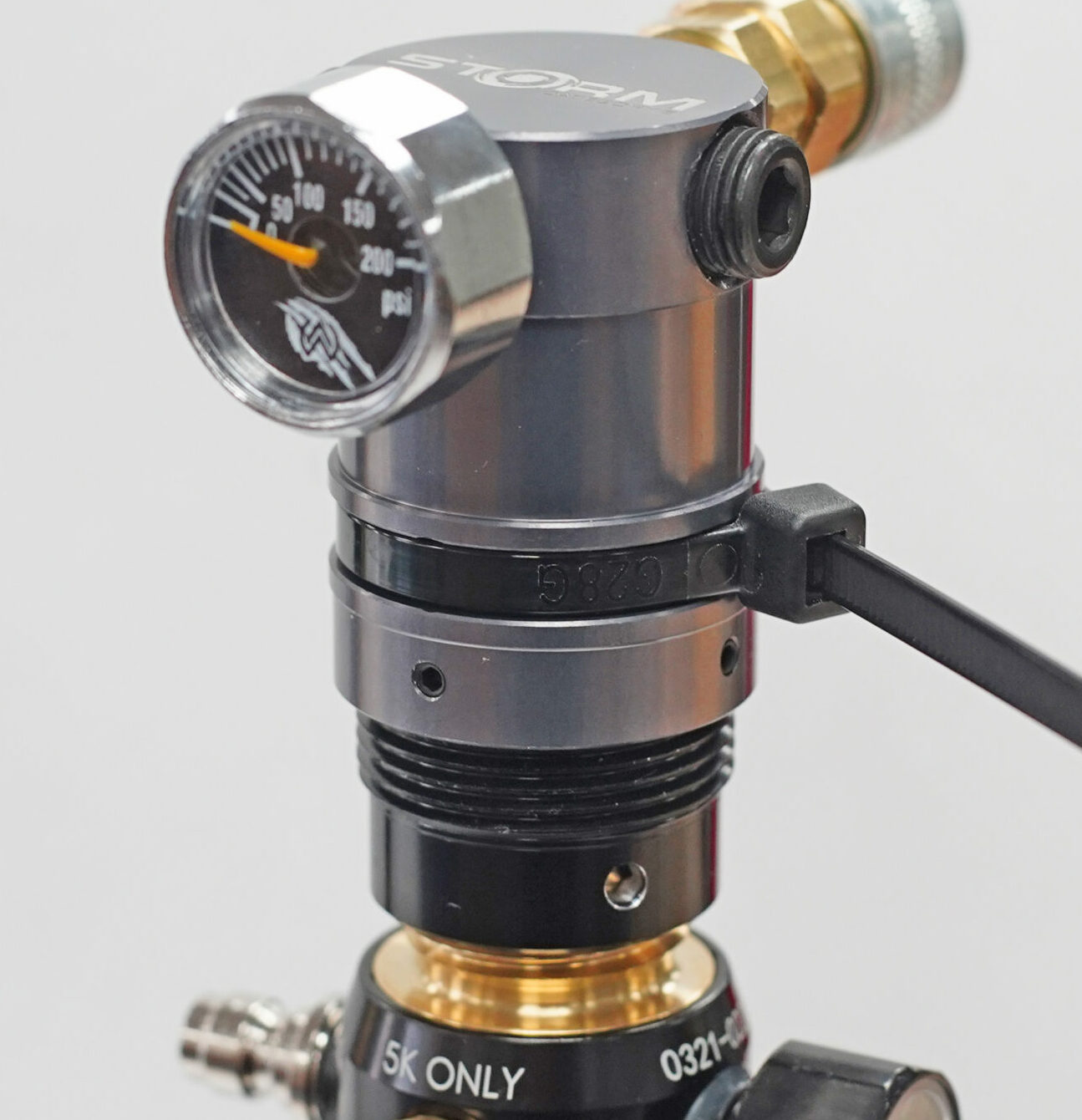 Airsoft-Druckregler mit Manometer, zeigt 0-200 psi. Hochdruckanschlüsse aus Metall und Kunststoffelemente sichtbar.