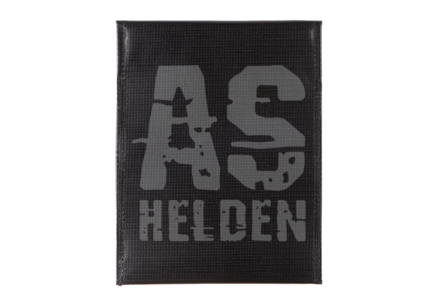 Schwarzes Patch mit grauem "AS HELDEN" Schriftzug in grober Textur.