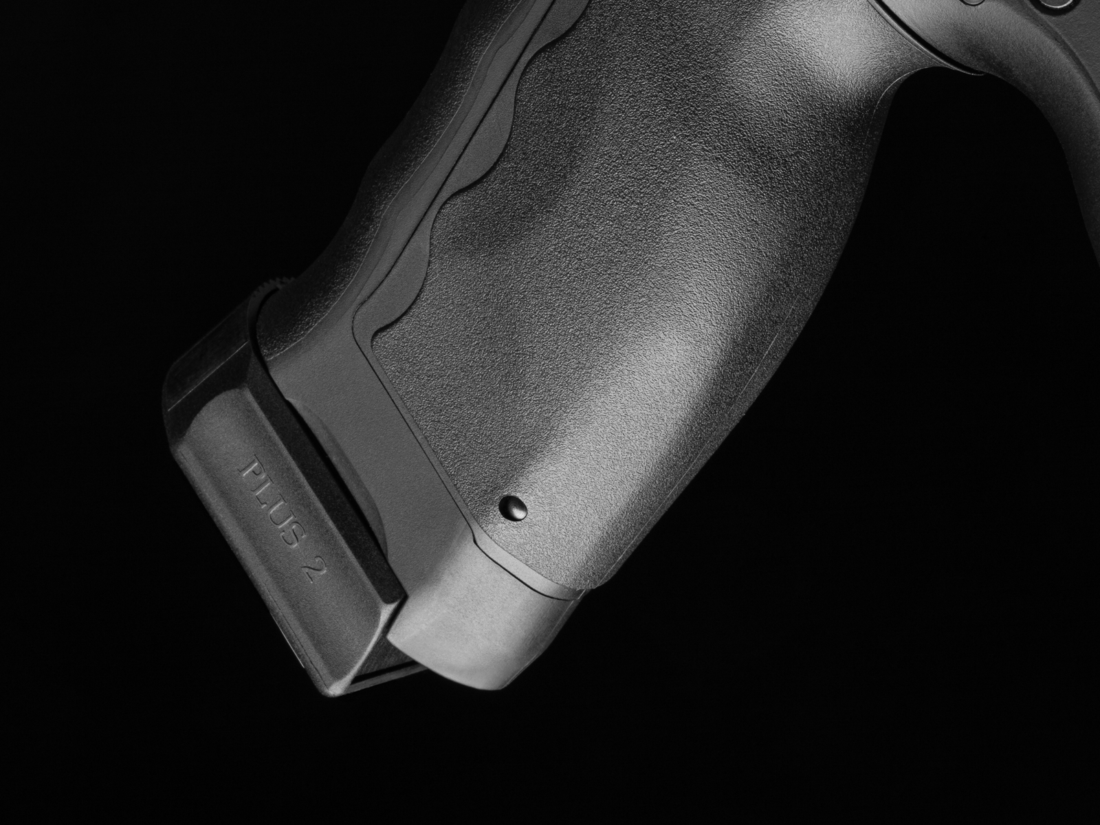 Rutschfester Airsoft-Griff mit Plus-2-Magazinverlängerung, Nahaufnahme, schwarzer Hintergrund.