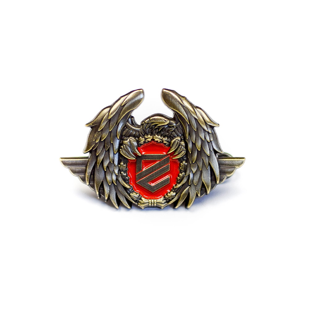 Metallabzeichen mit Flügeln, rotem Schild und Logo in der Mitte. Ideal für Airsoft-Kleidung oder Ausrüstung.
