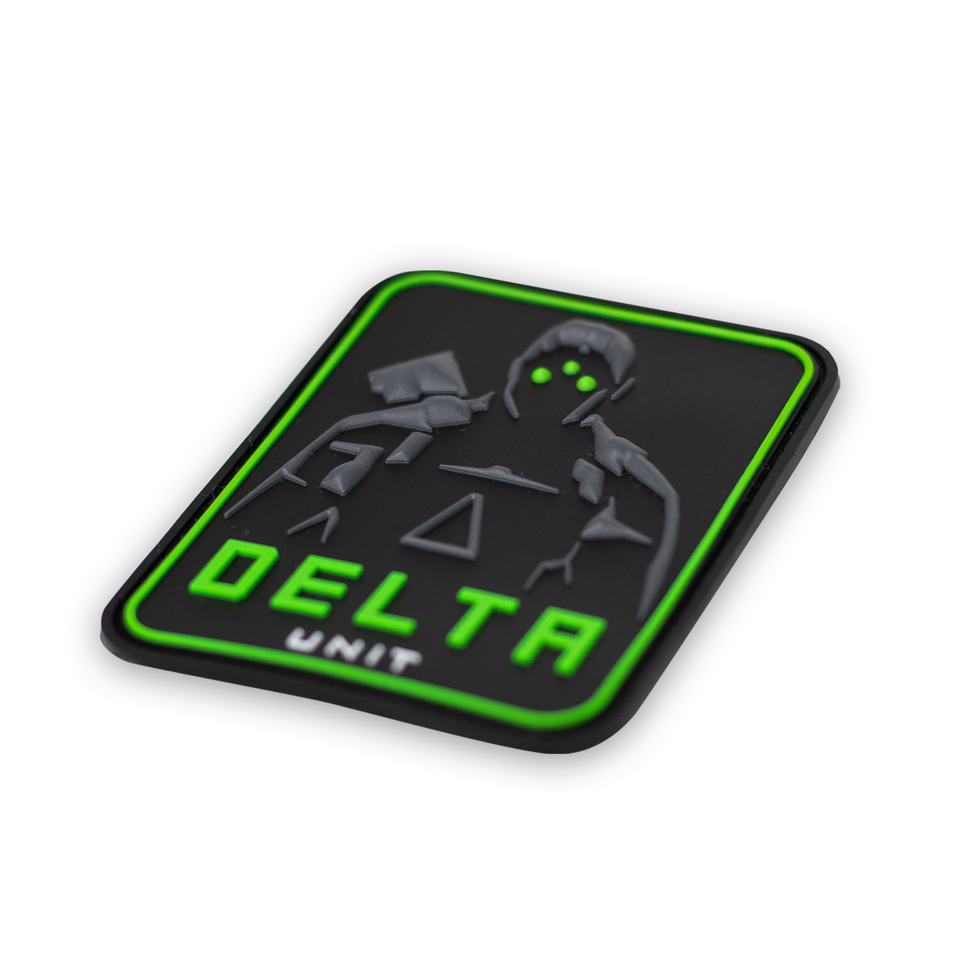 Schwarzes PVC-Patch mit neon-grüner Umrandung und "DELTA UNIT"-Text; stilisierte Figur im Hintergrund.