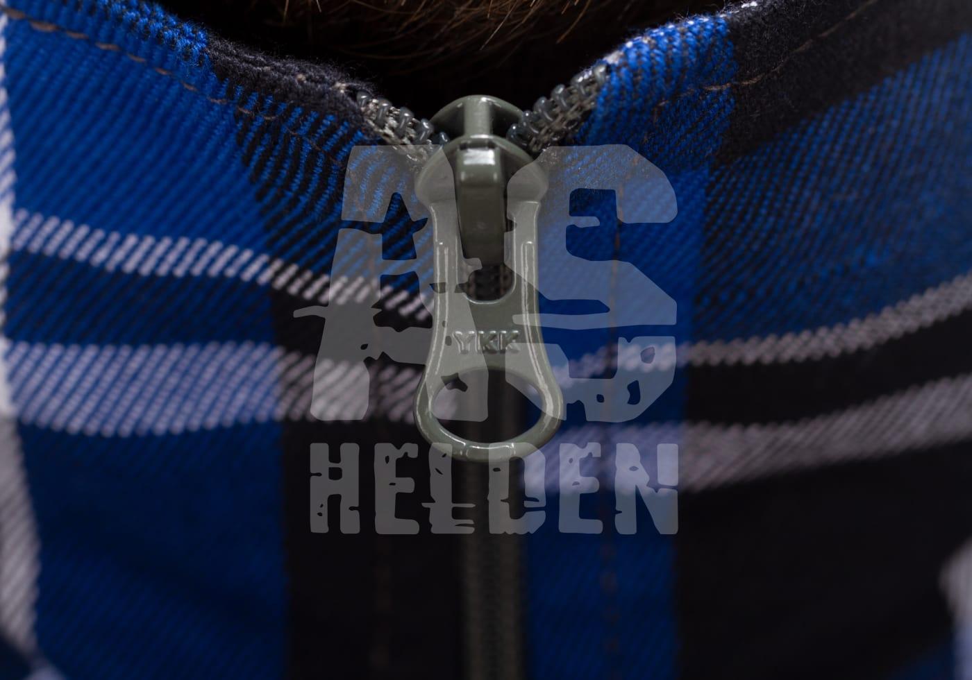 Flannel Combat Shirt Nahaufnahme eines blauen karierten Stoffes mit Reißverschluss, Logo im Vordergrund.