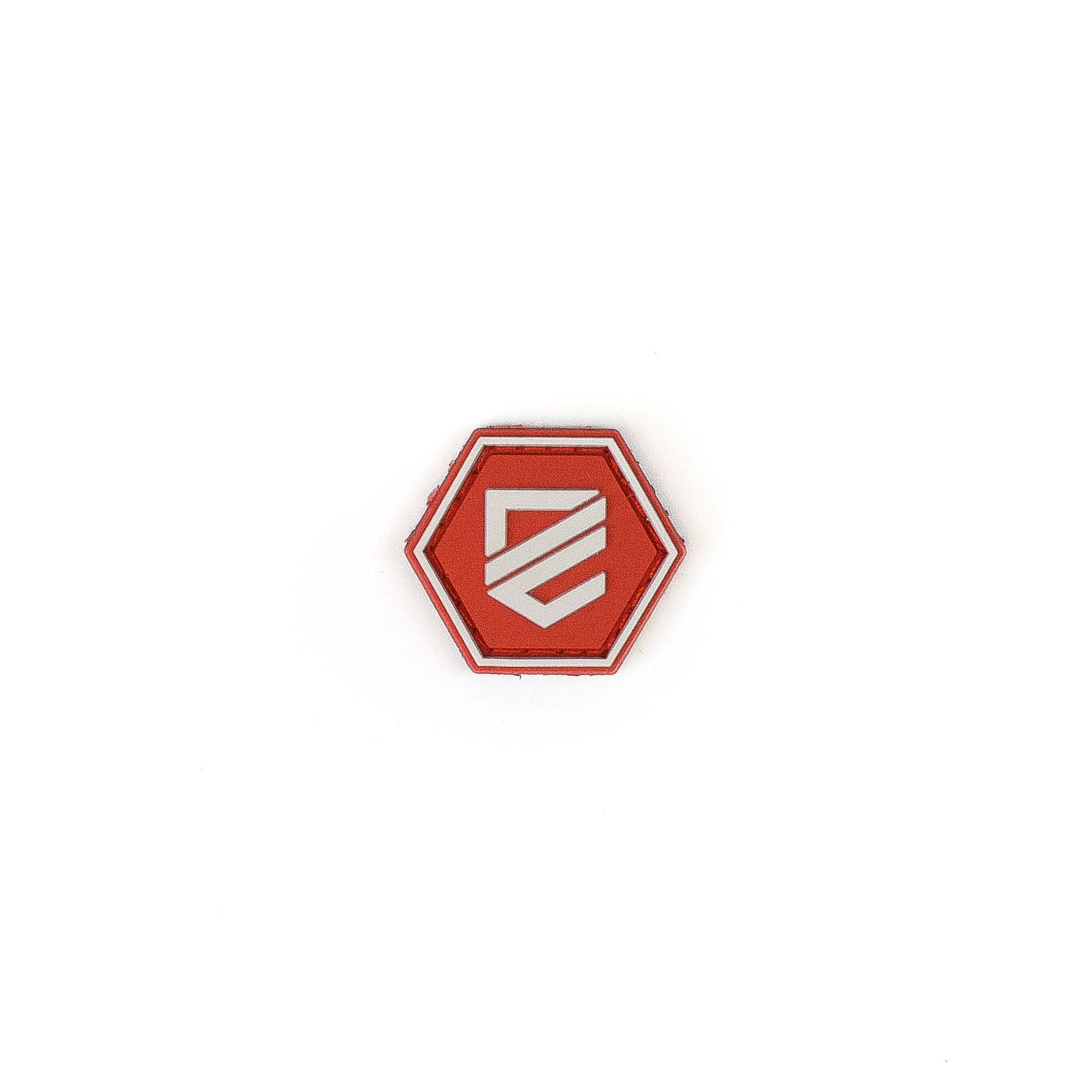 Rotes, sechseckiges Airsoft-Patch mit weißem Logo auf weißem Hintergrund.